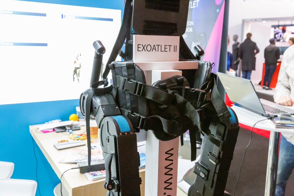 "Close-up of the Axoatlet II: Exoskeleton for medical rehabilitation and walking practice" by verchmarco is licensed under CC BY 2.0